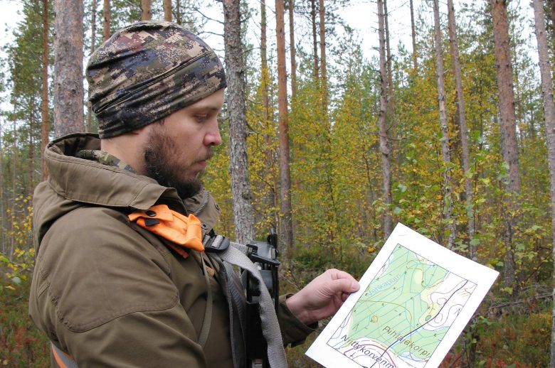 Mikko Ojamaa tutkii karttaa metsässä